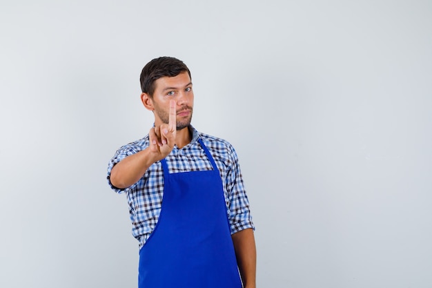 Young male cook in a blue apron and a shirt