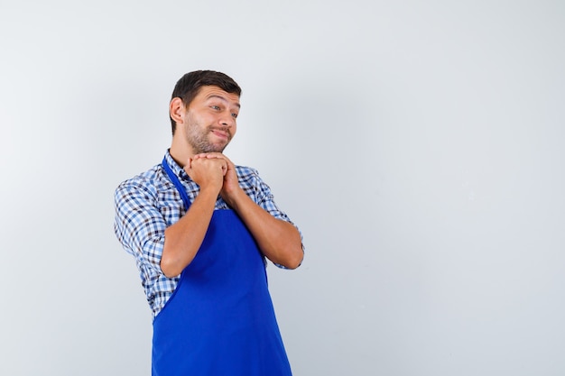 Young male cook in a blue apron and a shirt