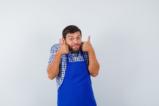 Young male cook in a blue apron and a shirt