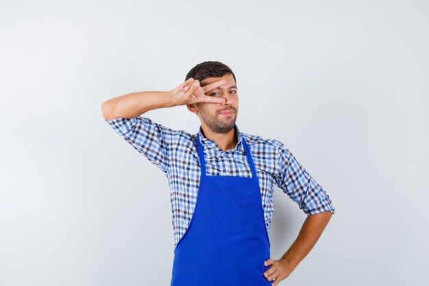 Young male cook in a blue apron and a shirt