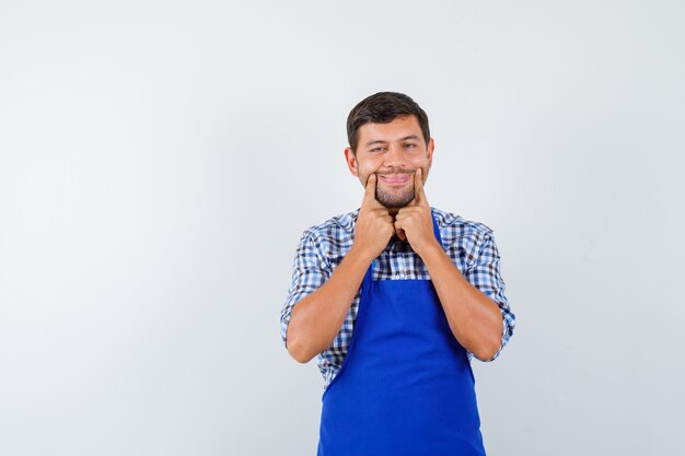 파란색 앞치마와 셔츠에 젊은 남성 요리사