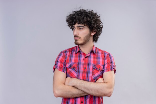 Young male curly hair isolated  colorful shirt crossed arms upset