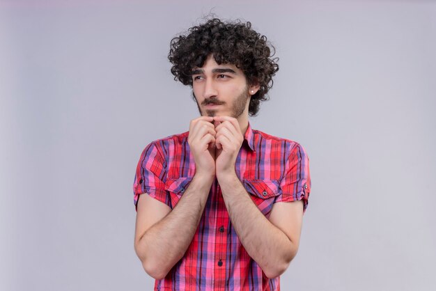 Young male curly hair isolated  colorful shirt scratching chin with both hands