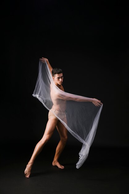 Young male dancing with transparent cloth
