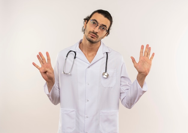 молодой мужчина-врач в оптических очках в белом халате со стетоскопом показывает разные числа