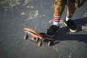 Бесплатное фото Молодой мужчина делает разные трюки со скейтбордом в парке