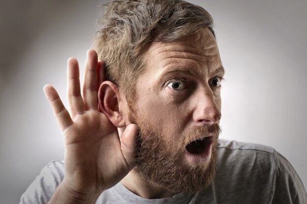 Young male doing a listening gesture