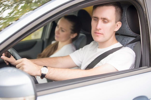 Young male driver looking at the side view mirrors