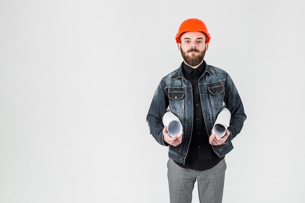 Free photo young male engineer holding blueprints in his hand