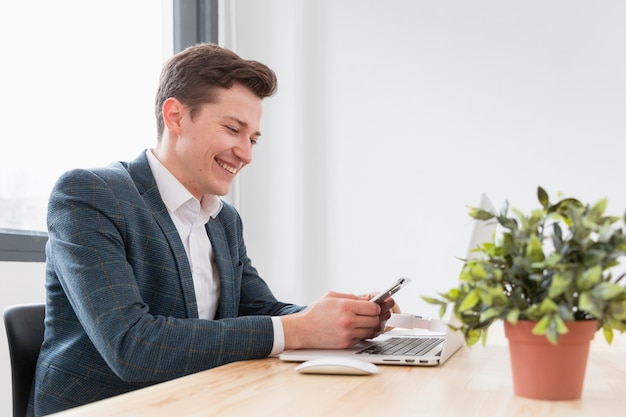 Foto gratuita giovane maschio che gode del lavoro dall'ufficio