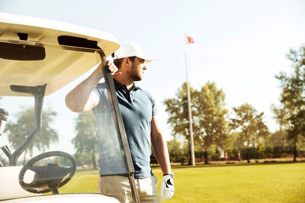 Young male golfer standing