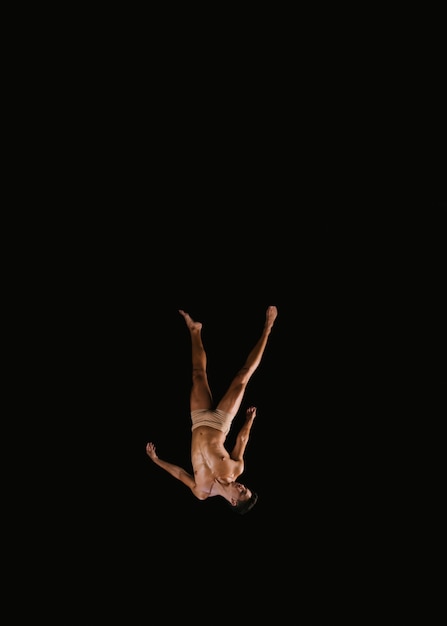 Young male gymnast flying upside down