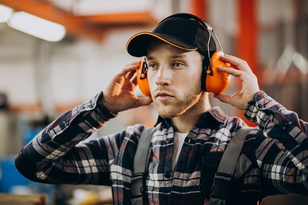 Free photo young male handyman with safety earphones