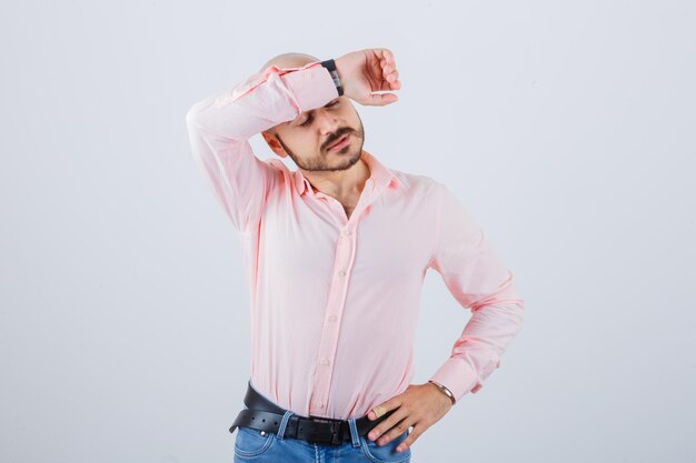 Free photo young male holding arm on the forehead