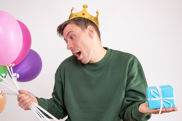 young male holding balloons and little present on white