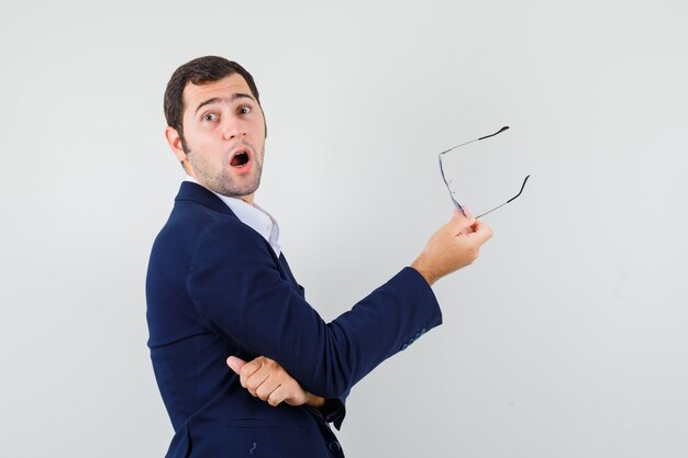 Free photo young male holding glasses in shirt