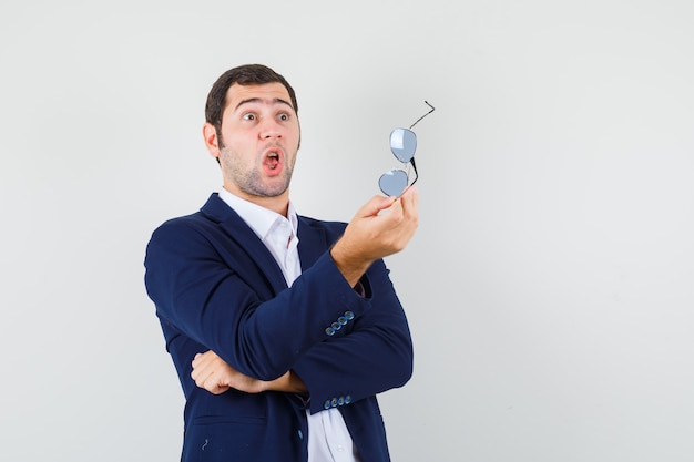 Young male holding glasses in shirt