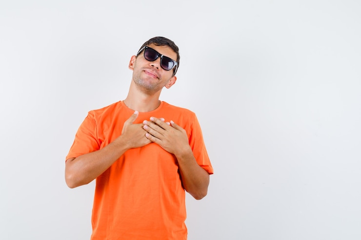 無料Photo オレンジ色のtシャツで心に手をつないで平和に見える若い男性