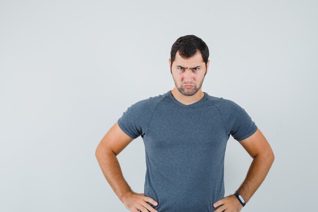 灰色のTシャツを着て腰に手をつないで真剣に見える若い男性