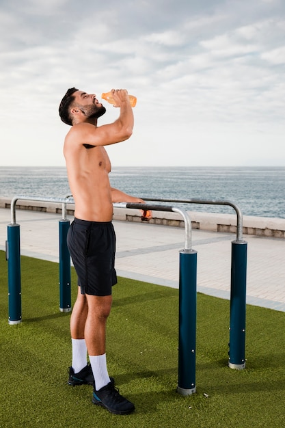 Free photo young male hydrating after exercising