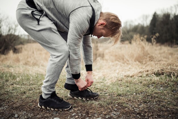 Young male jogger putting his sport shoes