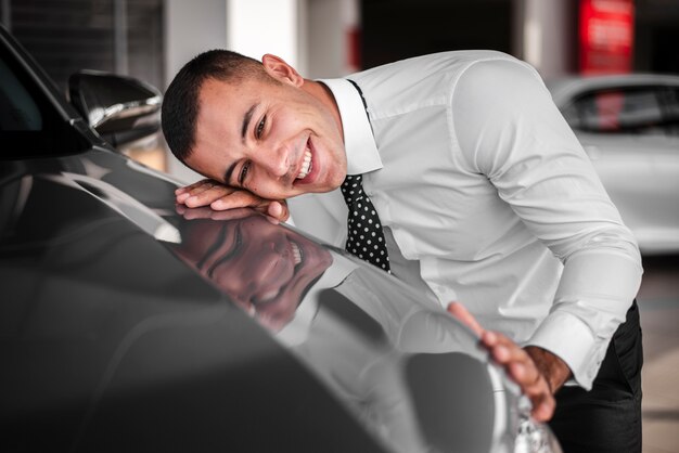 Young male leaning on new car