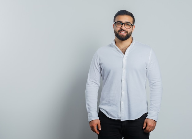 Young male looking at camera in shirt, pants and looking confident