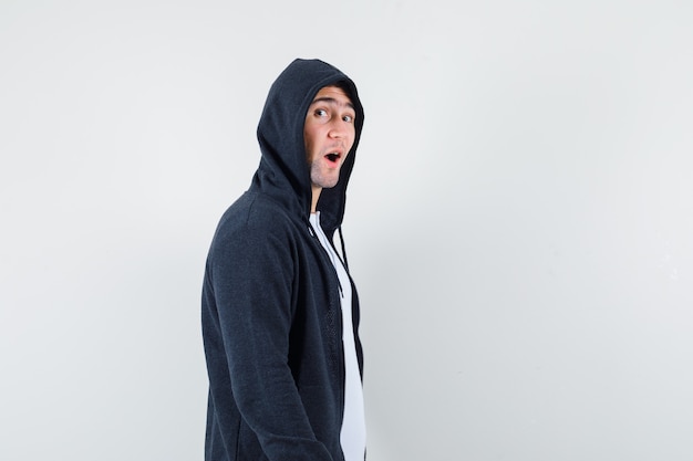 Young male looking at camera in t-shirt, jacket and looking amazed. .