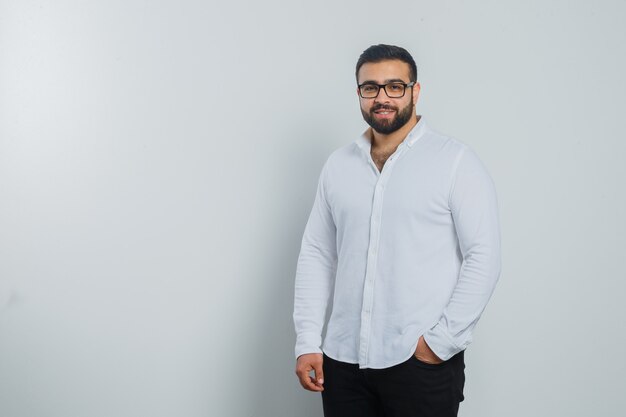 Young male looking at camera in white shirt, pants and looking handsome