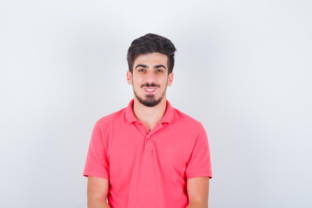 Young male looking in pink t-shirt and looking cheerful. front view.