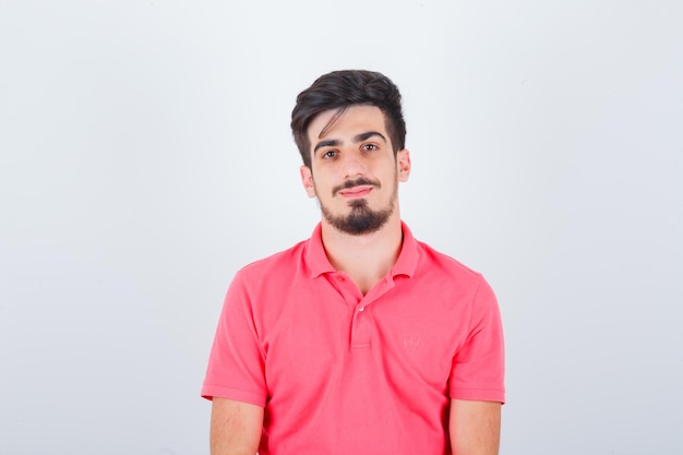 Young male looking in pink t-shirt and looking sensible , front view.