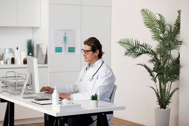 Young male pediatrician working at his office