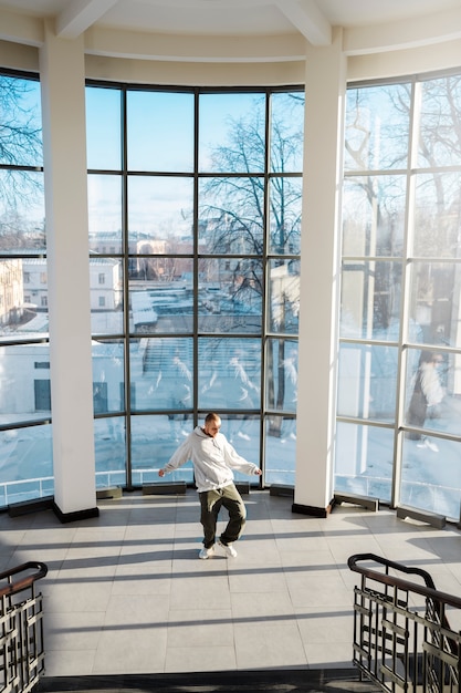 Young male performer dancing in a building with big windows