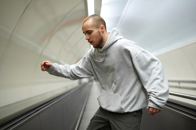 Young male performer dancing on escalators