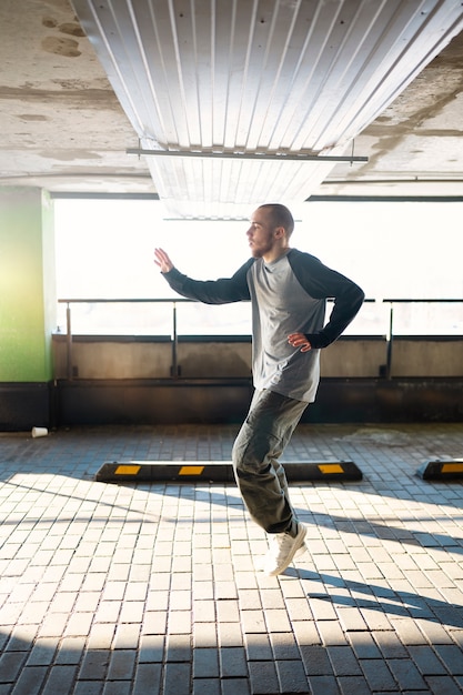 Young male performer dancing in a parking lot with pilons