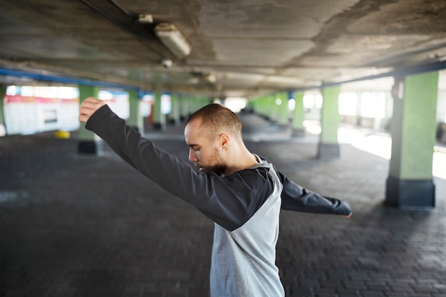 Young male performer dancing in a parking lot with pilons