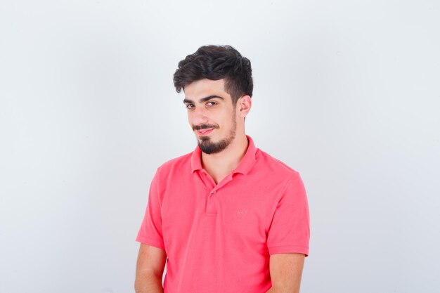 Young male in pink t-shirt looking and looking sensible , front view.