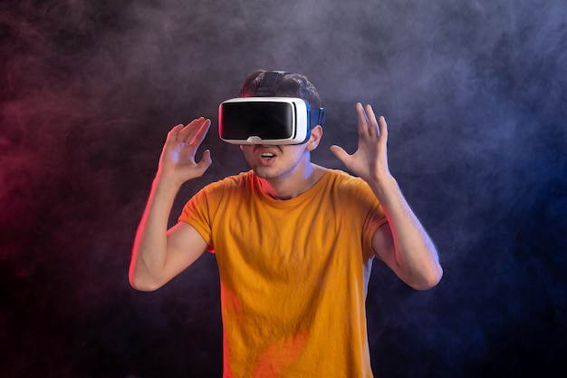 Молодой мужчина играет в страшную игру в темной поверхности виртуальной реальности