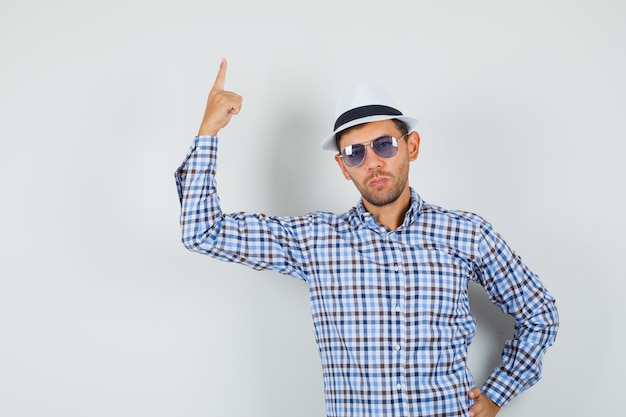 Young male pointing finger up in checked shirt