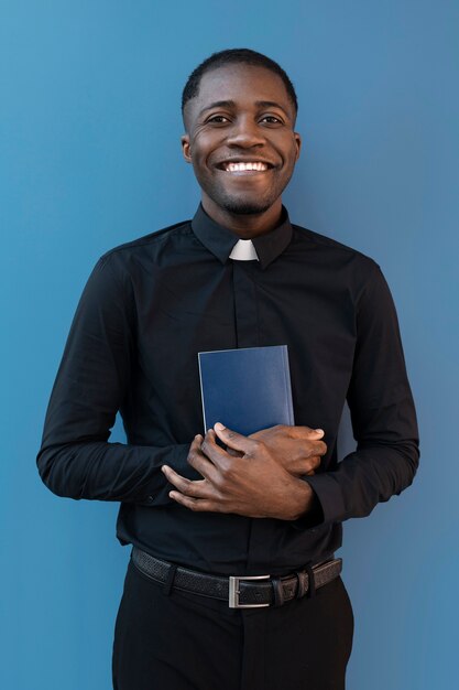 Молодой священник держит книгу
