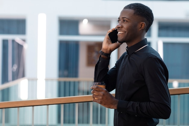 Young male priest talking on smartphone