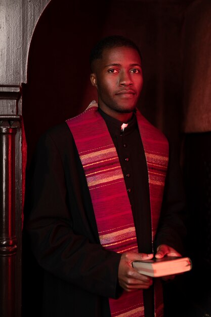 Young male priest with a bible in the church