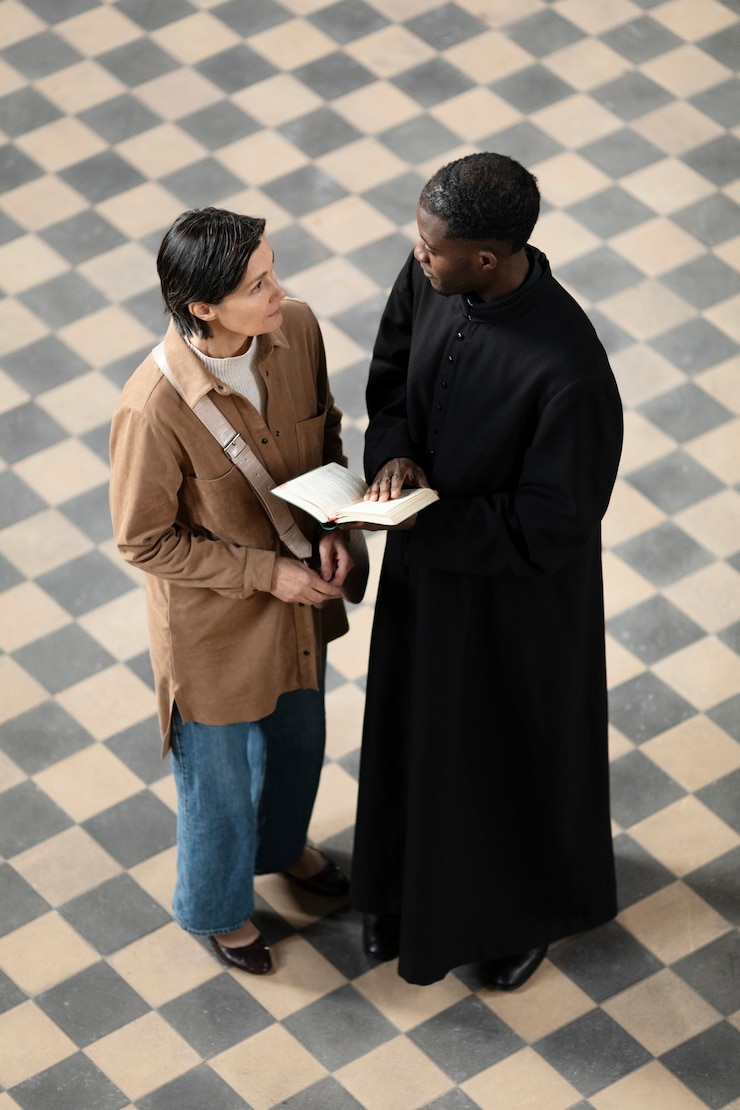 Free Photo young male priest and woman talking in the church while holding a bible