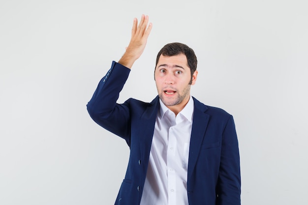 Young male raising hand in shirt