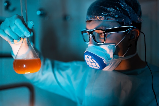 Young male researcher carrying out scientific experiment.