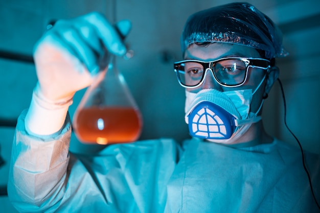 Young male researcher carrying out scientific experiment.