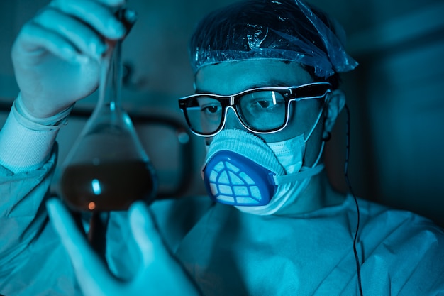 Young male researcher carrying out scientific experiment