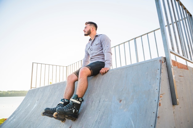 스케이트 공원에 앉아 젊은 남성 rollerskater