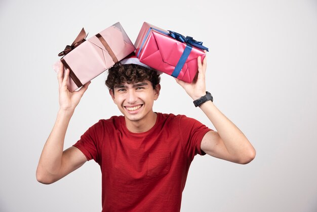 Young male in Santa hat holding gifts  