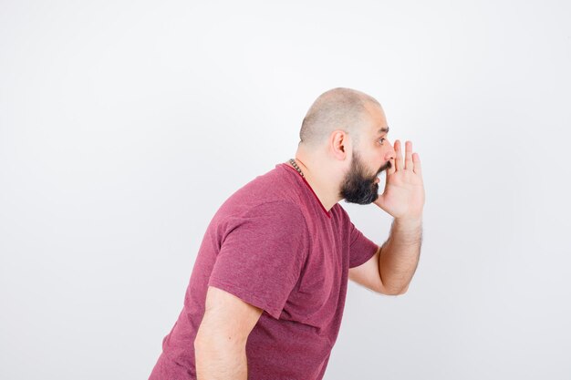 Young male shouting for someone in pink t-shirt and looking energetic. .